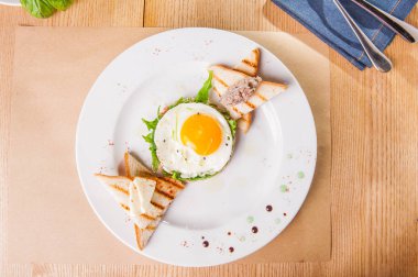 Üstten Görünüm kızarmış yumurta, tost ve hizmet ahşap masa üzerinde beyaz tabakta et pate ile kahvaltı. Seçici odak, kopya alanı