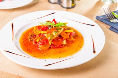 Fesleğen yaprak hizmet woodan masada beyaz tabakta süslenmiş sebzeli güveç balık fileto kadar kapatın. sağlıklı gıda, lezzetli lunched. Seçici odak