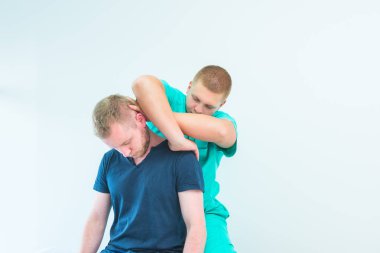 Erkek Hasta terapist masaj alma. Hastanın boynuna tıbbi ofiste uzanan bir masör. Nörolojik fizik muayenesi. Osteopati, chiropractic, fizyoterapi. Izole.