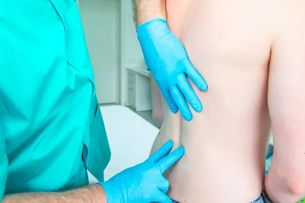 Närbild manlig neurolog läkare diagnostiserar länd ryggen av manlig patient i medicinsk klinik. Neurologisk undersökning. Osteopati, kiropraktik, fysioterapi — Stockfoto