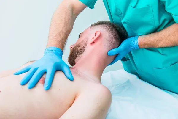 Manlig patient som får massage från terapeut. En kiropraktor stretching hans patientens hals i medicinska kontor. Neurologisk undersökning. Osteopati, kiropraktik, fysioterapi. Isolerade. — Stockfoto