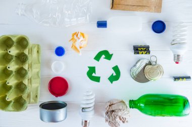 Geri dönüşüm. Yeşil geri dönüşüm eko sembolü. Geri dönüştürülmüş oklar geri dönüşüm ve beyaz ahşap arka plan üst görünümünde yeniden kullanmak için matherials yakın işareti.
