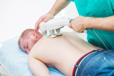 Doktor transkraniyal manyetik stimülasyon yapıyor, sırtın elektroterapötik tedavisi. Bir chiropractor hastanın torasik omurga tedavi eder. Fizyoterapi. Nöroloji, Osteopati, chiropractic.