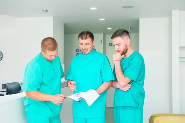 Grupo de pessoal médico discutindo os resultados do paciente na clínica. Profissionais de saúde discutem no hospital. Médico experiente explicando smth e educando estudantes de medicina. Espaço de cópia . — Fotografia de Stock