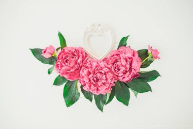 Beyaz arka plan üzerinde şakayık çiçekler kompozisyon ve kalp şekli fotoğraf çerçevesi ile Düzen. Sevgiler, düğün. Sevgililer Günü Çiçek maket. Tebrik kartı. Düz yatıyordu, üstten bak. Vintage tonlama görüntü. Kopyalama alanı.