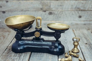 Ahşap rustik arka plan üzerinde pirinç tepsiler ile Antik vintage ölçüm ölçek ağırlıkları. Seçici odaklama, kopyalama alanı.