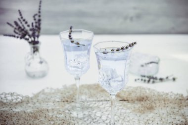 Beyaz ahşap masa üzerinde güzel gözlük çiçek ve buz küpleri ile taze lavanta limonata. Detoks suyu. Yaz içkisi. Diyet kokteyli. Seçici odak. Kopyalama alanı.