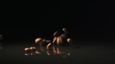 Kahve çekirdekleri yüzeye karanlık bir arka plan üzerine düşmek..