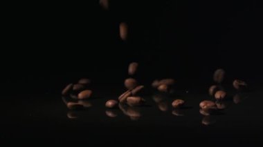 Kahve çekirdekleri yüzeye karanlık bir arka plan üzerine düşmek..