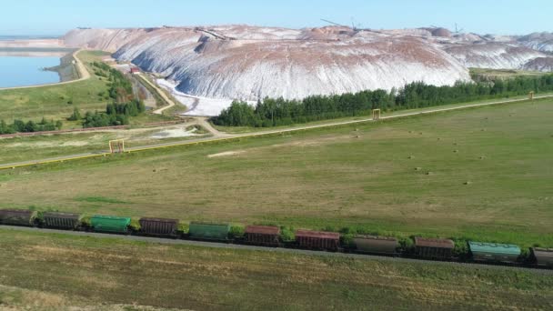 Tuz yığınları, Sanayi ocakları hava görünümünü yakınındaki demiryolu seyahat tren yük, yükseklikten görüntüleme. — Stok video