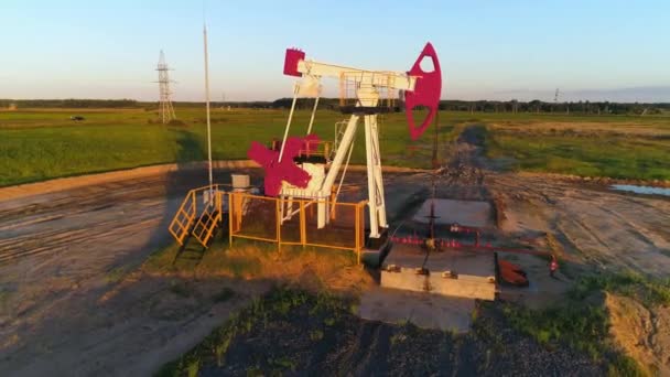 燃料の生産、フィールドで油をポンプ、油ポンプ、夕日の光の高さからの眺め. — ストック動画