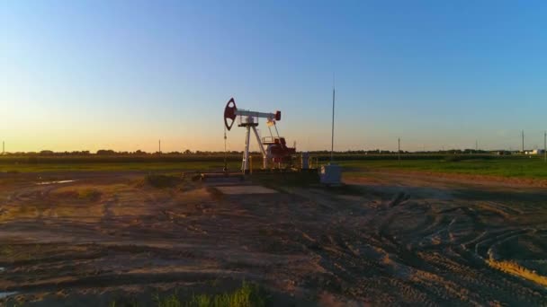 Produção, bomba de óleo, bombeamento de petróleo no campo de combustível, vista de altura, luz do sol. — Vídeo de Stock