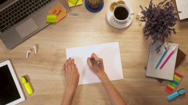 Kız bir kağıda birinci şahıs bakış el iş masada oturan bir ev çizer.