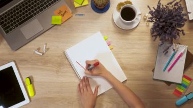 Kız bir kağıt parçası üzerinde bir ifade - yazar serbest, birinci şahıs bakış el iş masada oturan.