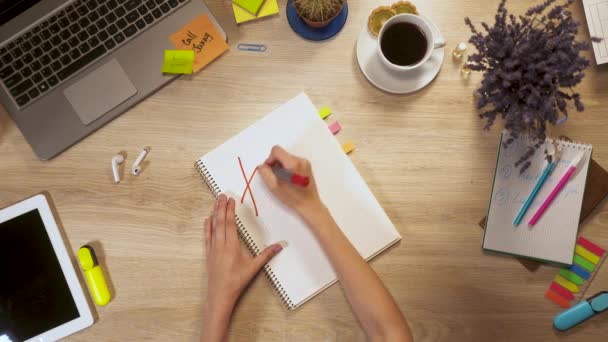 Girl writes on a piece of paper a phrase - Happy Day, sitting at work table, first-person view of hands. — Stock Video