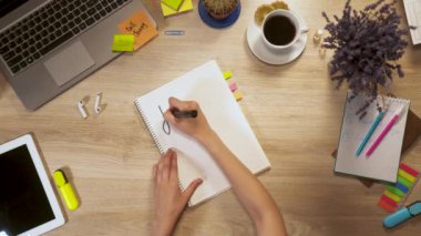 Bir parça kağıda bir ifade - öğrenme Fransızca, birinci şahıs bakış el iş masada oturan kız yazar.