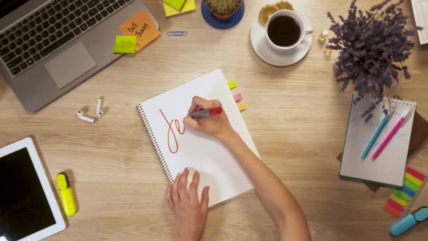 Dívka píše na kousek papíru fráze - výuka angličtiny, u pracovního stolu, first-person pohled rukou. — Stock video