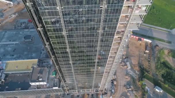 Будівництво, повітряний вид на будівлю скляного хмарочоса, вид з висоти бізнес-центру, відображення в склі, сонячне світло . — стокове відео