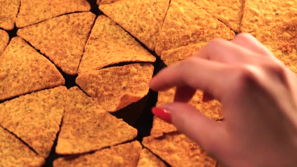 Dívka bere nachos chips z tabulky. — Stock video
