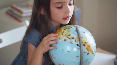 Küre dünya coğrafyası okuyan kız öğrenci sınıfta,.