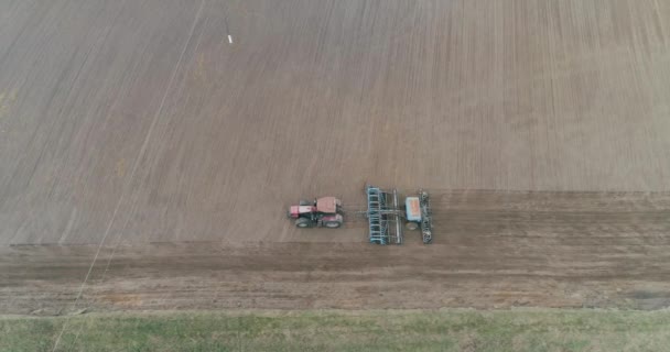Campo y la agricultura, siembra de grano tractores Aran de la tierra en el campo, vista desde la altura. — Vídeo de stock