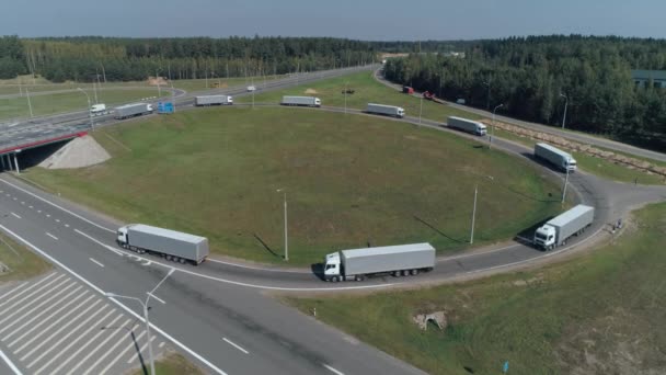 Comboio de caminhões de passeio na rodovia, a junção de estrada perto de floresta, transporte logístico, vista da estrada de altura. — Vídeo de Stock