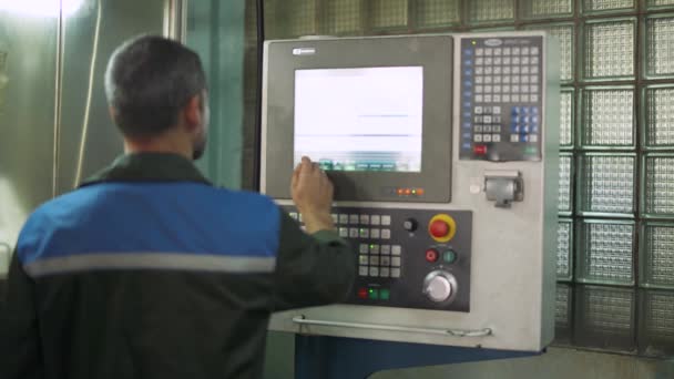 Produktion av klockor, ingenjör som arbetar man justerar produktionslinje maskinens kontrollpanel, automatisk produktion. — Stockvideo