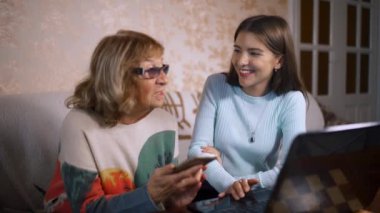 Smartphone, ev iç kullanmak için yaşlı bir kadın gönüllü kız öğretir.