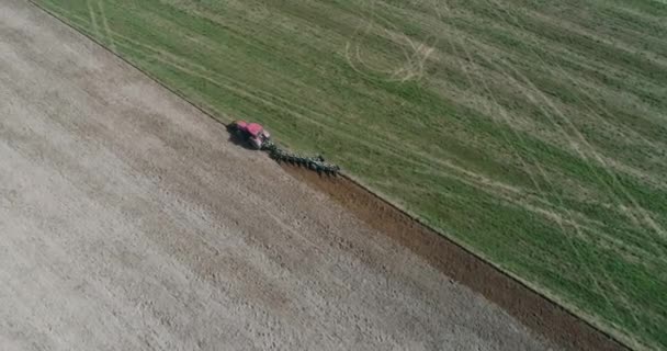 Platteland en landbouw, graan zaaien, boerderij Tractoren ploegen de aarde in veld uitzicht vanaf hoogte. — Stockvideo