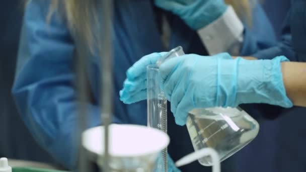 Laboratorio, un scoolgirl en gafas de protección vierte líquido en tubo de ensayo, experiencia química, Educación de los niños. — Vídeos de Stock