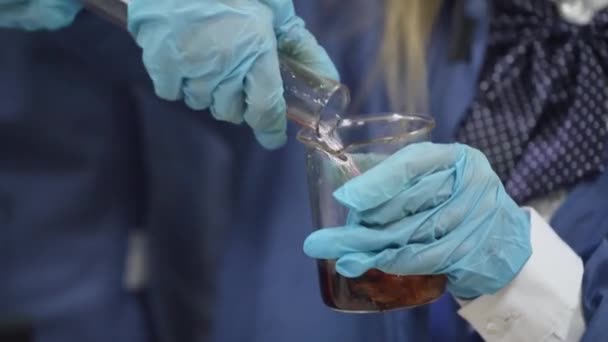 Laboratorio, una colegiala en gafas protectoras vierte líquido en tubo de ensayo, experiencia química, Educación de los niños. — Vídeos de Stock