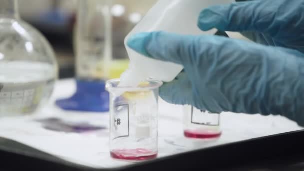 Laboratório, um estudante derrama líquido em tubo de ensaio, experiência de química, educação de filhos. — Vídeo de Stock