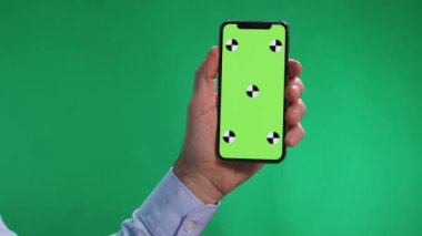 Erkekler kullanma smartphone chromakey içinde tokatlamak ekranında, bir fotoğraf ve tıklama tablet ekranında, yaşasın arka plan yeşil.