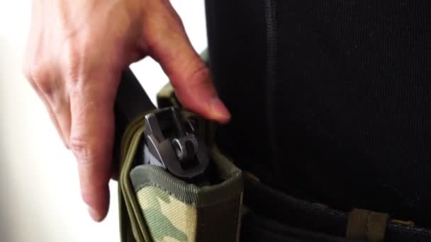 Офицер полиции кладет руку на пистолет в кобуру - крупным планом — стоковое видео