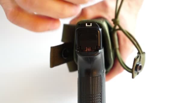 Mannelijke handen fix het pistool in de holster close-up — Stockvideo