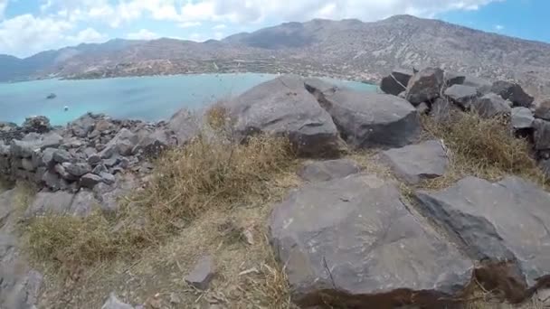 Pasos de pie de excursionista senderismo al aire libre. caminar pies en terreno rocoso ruinas griegas antiguas pov spinalonga concepto de viaje — Vídeo de stock