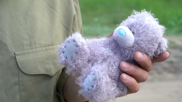 Чоловік тримає плюшевого сірого ведмедя дитяча іграшка відчуває ностальгію прищипніть її до серця, дитячі спогади, сумний момент життя, емоції — стокове відео