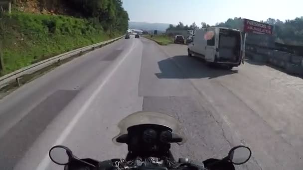 Motociclista Passeios em uma bela paisagem Mountain Road na Sérvia. Vista em primeira pessoa. VPO. Mototravel. Miradouro de um motociclista descendo uma estrada cênica e vazia em direção às montanhas, tiro de ação — Vídeo de Stock