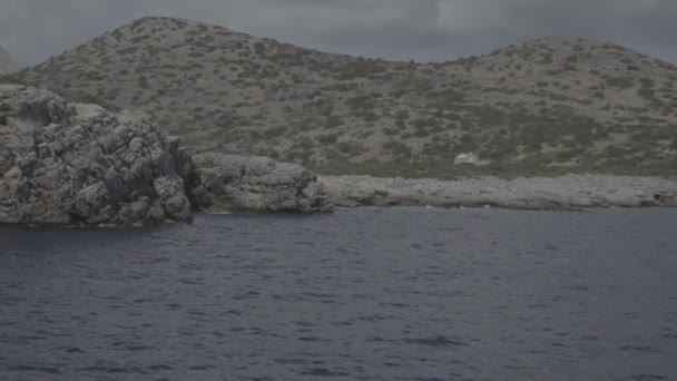 Luz cintilante através de uma baía de ilhas gregas rochas — Vídeo de Stock