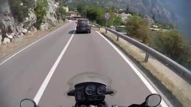 Езда на мотоцикле по сельской дороге горы Черногории, гастроли приключений, pov выстрел на экшн-камере boka kotorska зрения, красивые высокие каблуки — стоковое видео