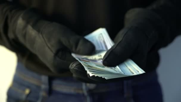 Przestępczości koncepcja człowieka w czarne skórzane rękawiczki gospodarstwa kupę pieniędzy — Wideo stockowe