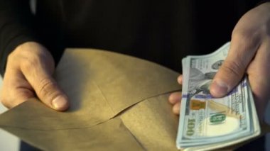 adam amican Doları para koyarak yığını zarf rüşvet eller.