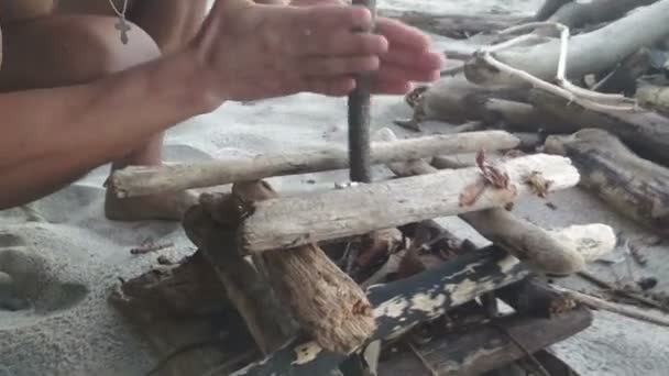 Человек пытается разжечь огонь по-старому — стоковое видео