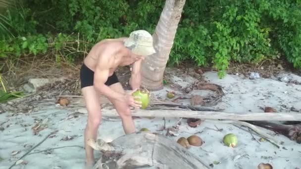 Hungriger Mann versucht Kokosnuss zu öffnen — Stockvideo