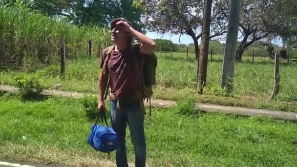 Backpacker viajante andando por belíssima estrada verde filmado na câmera do telefone móvel imagens amadoras calor muito quente escondido na sombra — Vídeo de Stock