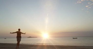 Genç kadın toplantı sunsire sahilde silüeti. Seyahat kavramı. Duygu iyi.