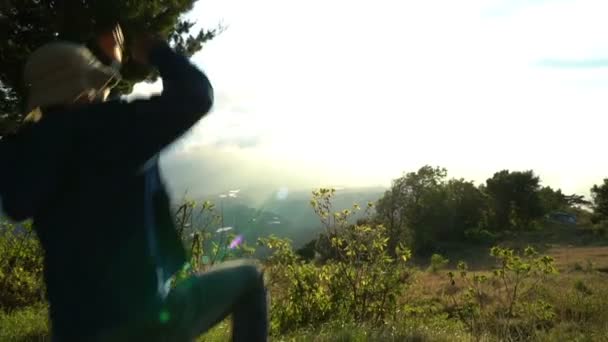上部に到達。幸せジャンプ男し、日の出の美しい山の風景に手を上げます。Feelling 良い。課題を克服します。概念旅行. — ストック動画