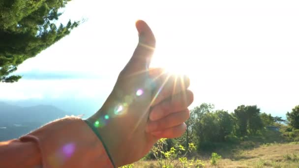 举起大拇指的手在晴朗的蓝天背景下再次阳光。表达的人 — 图库视频影像