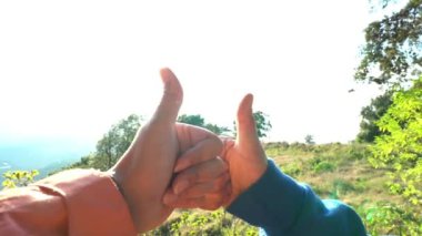 Başparmak-up üzerinde açık mavi gökyüzü ile yükselterek eller tekrar güneş ışığı arka plan. İfade insanlar