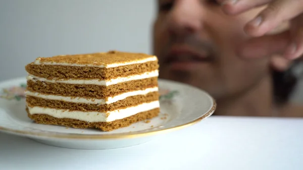Homem doce dente caça para um pedaço de bolo em um prato que ele esconde do que esgueirar-se para sua paixão — Fotografia de Stock